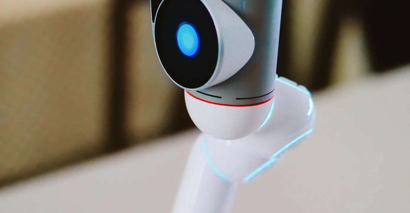 Close-up of a robotic device with a glowing blue sensor