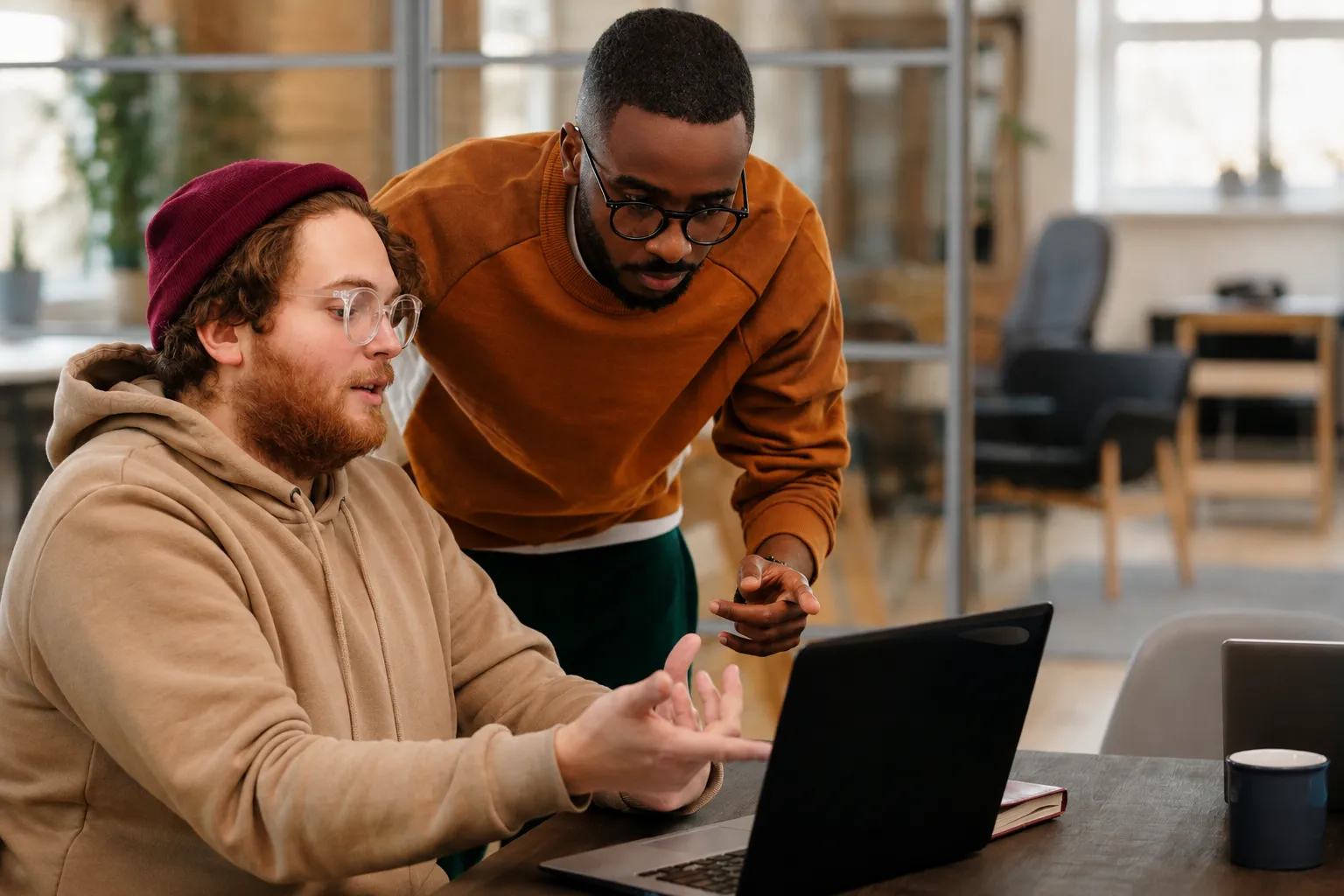 Two Cbayt team members collaborating over a laptop